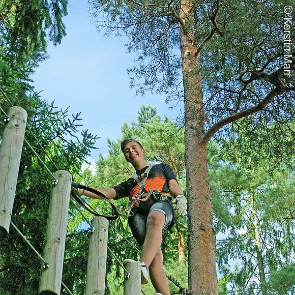 Sportlicher Junge im Kletterwald unterwegs