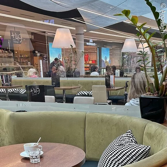 Arcaden Blick auf Cafe im ersten Obergeschoss, grüne Sitzmöbel