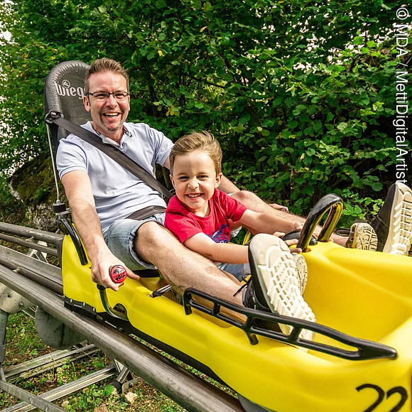 Vater und Sohn auf der Sommerrodelbahn