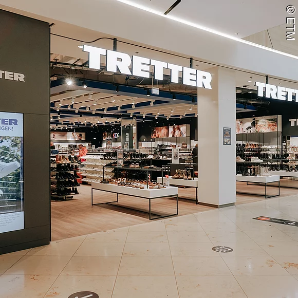 Ansicht auf Eingangsbereich des Ladens, großer Schriftzug über den Eingangsbereichen