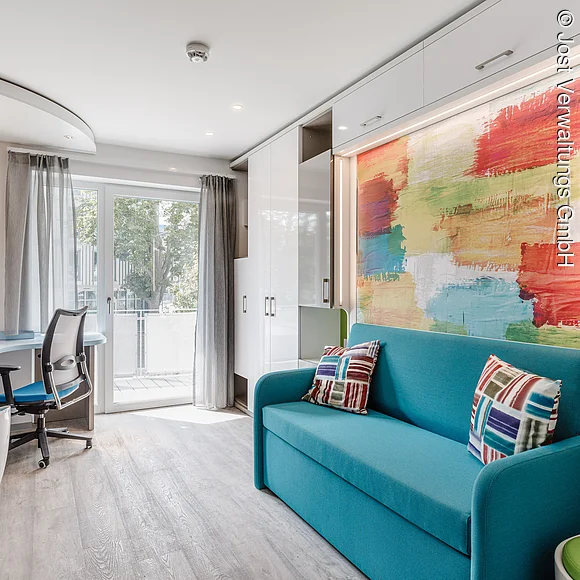 Hotelzimmer mit kleiner Küche, Arbeitsecke und Sofa