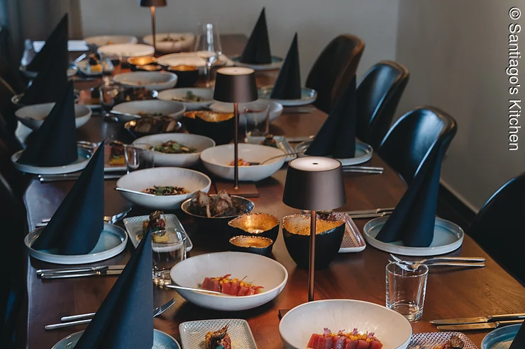Teambuilding Kochkurs Festlich gedeckte Tafel mit verschiedenen Gerichten auf weißen Tellern