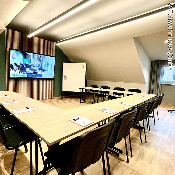 Seminarraum mit Bestuhlung in U-Form und Blick auf Präsentationbildschirm