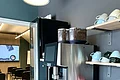 Kaffeeecke ausgestattet mit einem Kaffeevollautomaten, Teestation, Kaffeetassen und einem Getränkekühlschrank