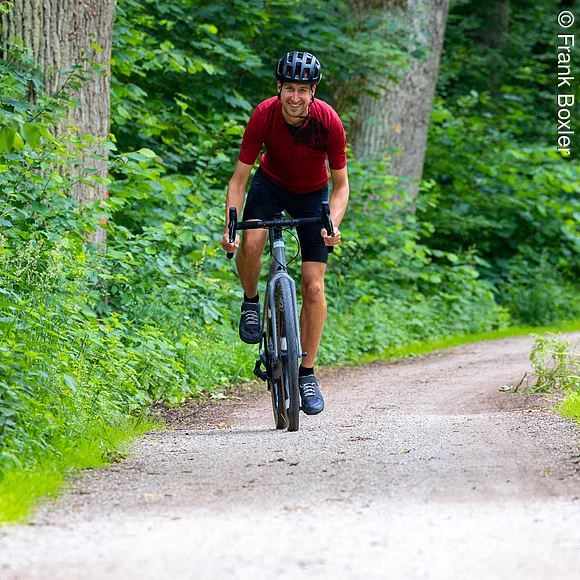Gravelbiker fährt durch Wald