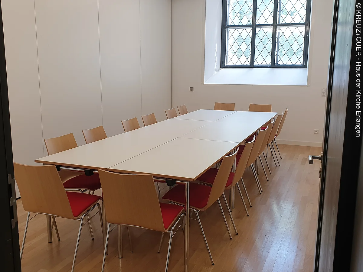 Seminarraum mit großem Tisch und zwölf Stühlen