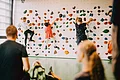 Kinder klettern an Kinderkletterwand und Erwachsene passen auf
