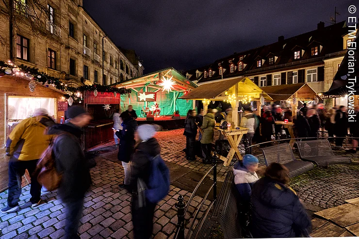 Personen stehen auf dem Altstädter Weihnachtsmarkt in Erlangen
