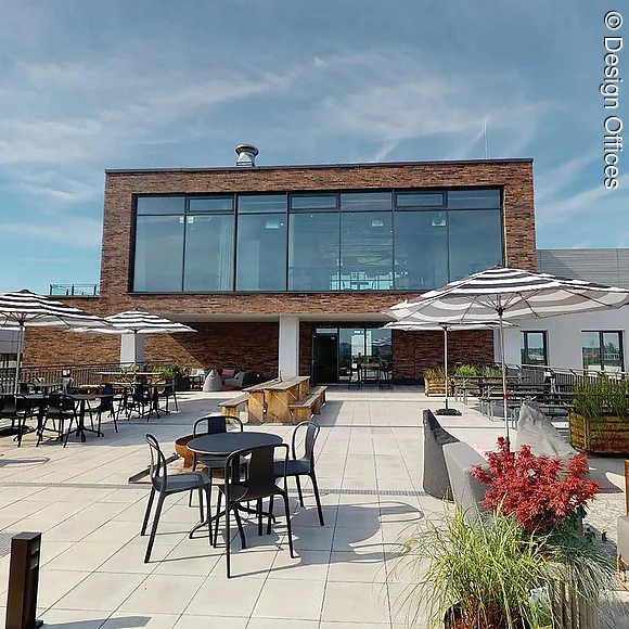 Dachterrasse Design Offices Dachterrasse mit Tischen,
Stühlen, Loungemöbeln und Sonnenschirmen. Block auf Gebäude