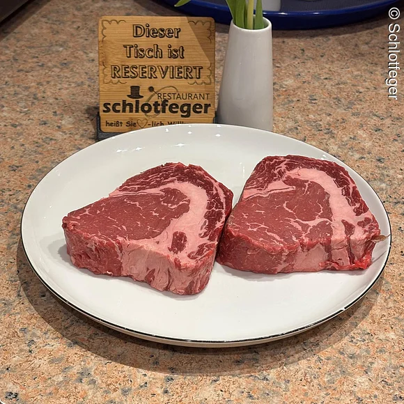 zwei rohe Steaks auf weißem Teller