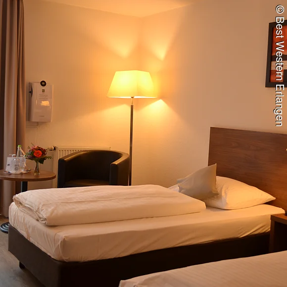 Zwei Einzelbetten, Stehlampen, Bild in einem Hotelzimmer.