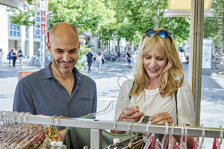 Paar bei der Kleiderauswahl beim Shopping in Erlangen