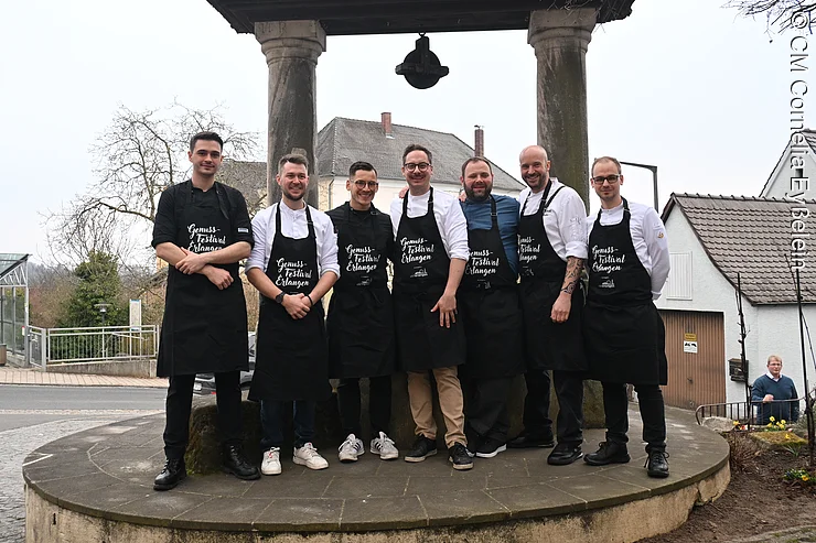 Sieben Köche vor dem alten Brunnen in Marloffstein als Gruppe