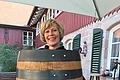 Seniorchefin der Fischerei Oberle vor einem Bierfass der Hofbräu Oberle